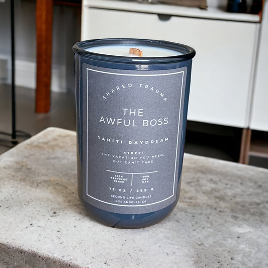 Candle in a blue container with a label on a concrete surface