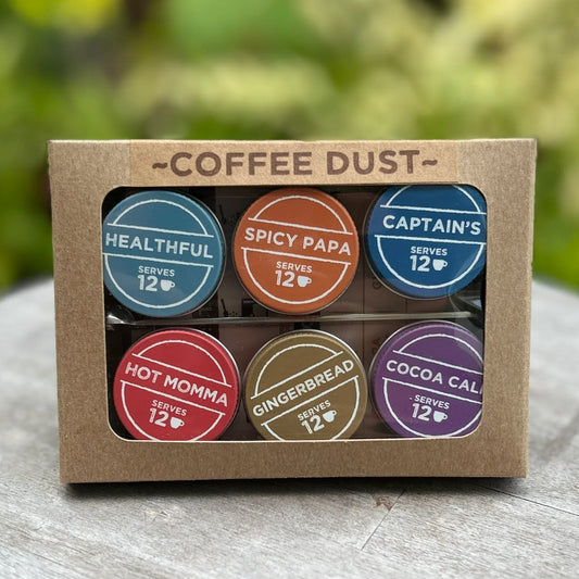 Box of Coffee Dust with colorful labels on a wooden surface