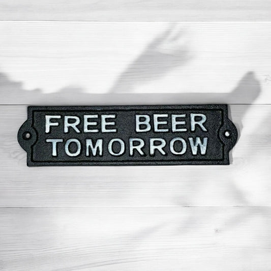 Black metal sign with 'FREE BEER TOMORROW' text on a white background