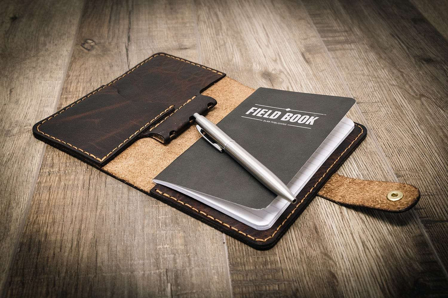 Field book with leather cover on a wooden surface