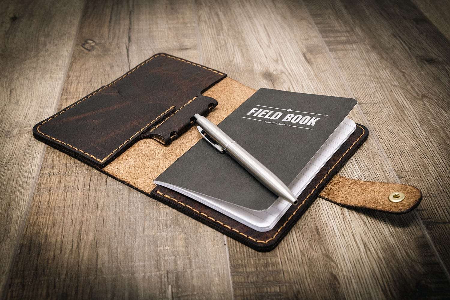 Field book with leather cover on a wooden surface