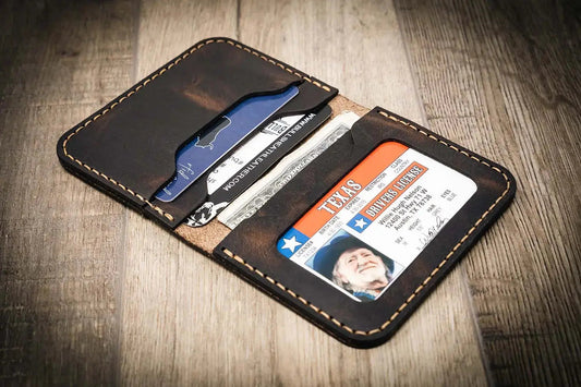 Brown leather wallet with cards and an ID on a wooden surface